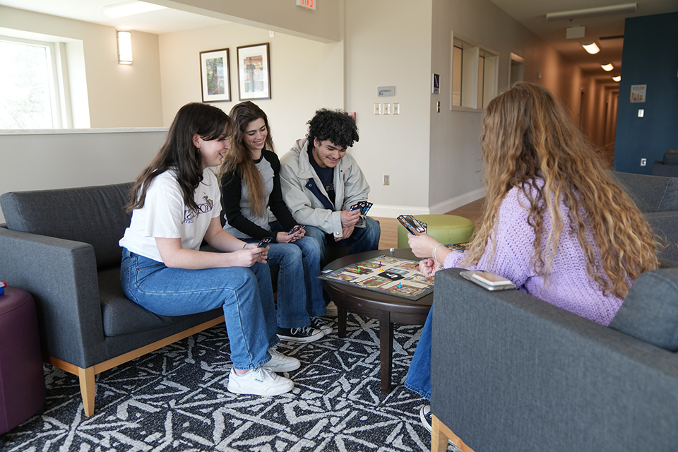 Four Converse play cards in a residential hall on campus.